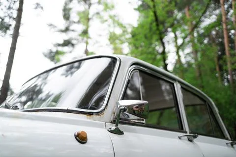 Upper part of a white vintage rusty auto in the forest, window, glass, door Stock Photos