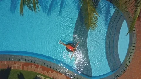 Upper picture lady swims on ring in oval pool Stock Footage 92718197
