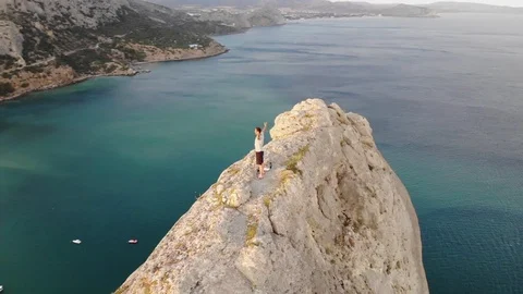 Upper round motion man raises hands on huge cliff top Video stock 103181075