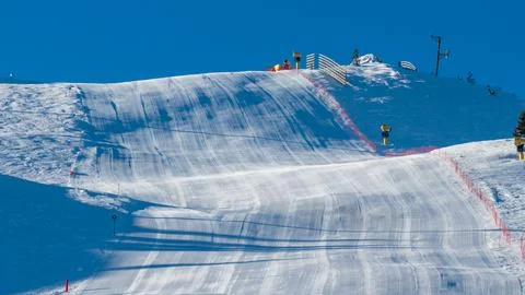 Upper section of a groomed ski slope under clear blue sky, featuring alpine.. Stock Photos
