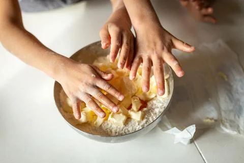 Upper view of childdren's hands putting butter in the bowl 스톡 사진