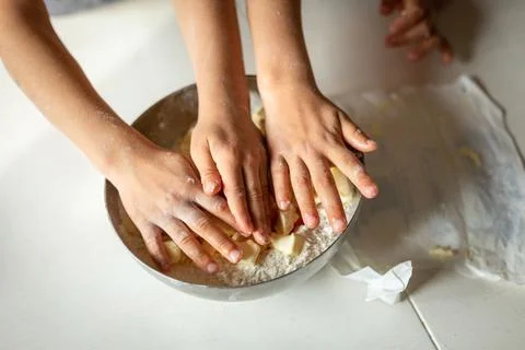 Upper view of childdren's hands putting butter in the bowl Stock Photos