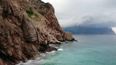 Upper view cliff by turquoise sea against gray cloud Video stock 103182611