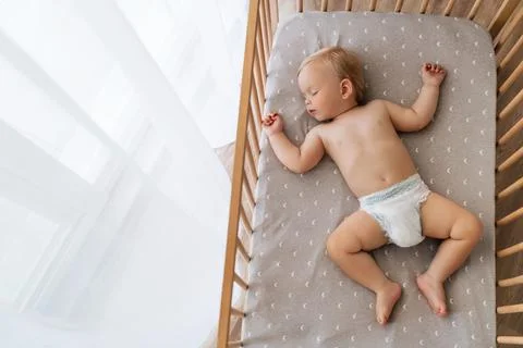 Upper view copy space portrait of cute baby sleeping in his bed lying on back Stock Photos