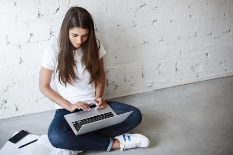 Upper view of creative young female, using laptop while sitting on floor Stock Photos