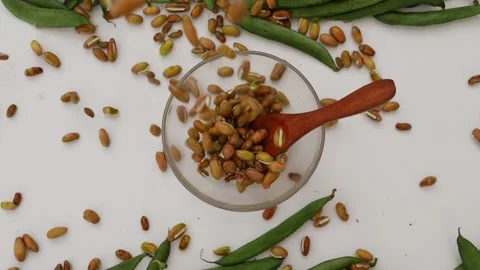 Upper view of falling beans seeds in transparent glass bowl 動画素材 159638262