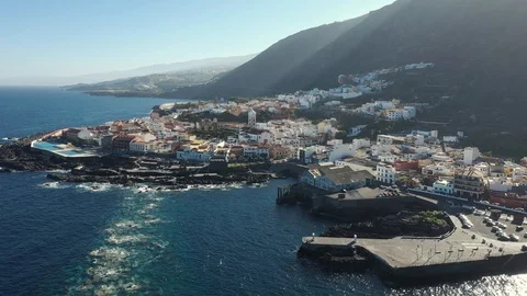 Upper view resort city lit by sun rays from behind hill Stock Footage 101961910