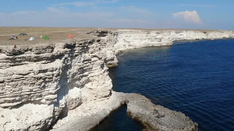 Upper view rocky cliffs with people cars and tents by sea Video stock 103183112