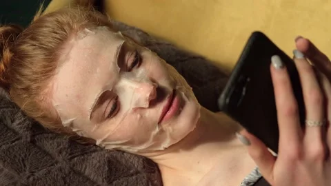 Upper view video of a caucasian ginger woman chatting on mobile while lying on Stock Footage 150857931