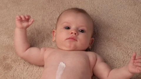 Upper view video of a caucasian parent applying special cream on the newborn Stock Footage 152349571