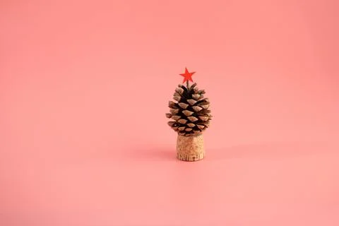 Upright pine cone with red star on cork base, solid light pink background, .. 写真素材