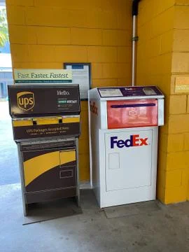 A UPS and FedEx drop boxes in a garage next to an office building Stock Photos