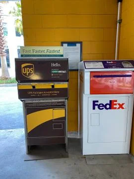 A UPS and FedEx drop boxes in a garage next to an office building Fotos de archivo