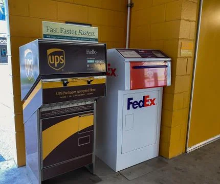 A UPS and FedEx drop boxes in a garage next to an office building Fotos de archivo
