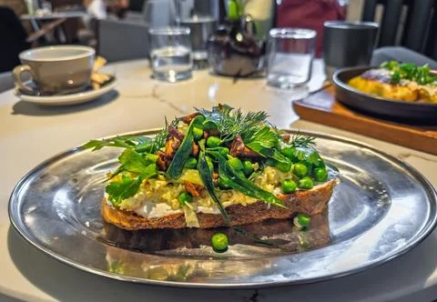 An upscale brunch dish: A piece of rustic sourdough toast topped with egg Stock Photos