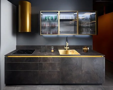 Upscale flat design kitchen with induction black glass hob with cylinder golden Stock Photos