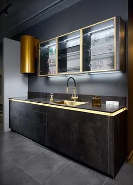 Upscale flat design kitchen with induction black glass hob with cylinder golden Stock Photos