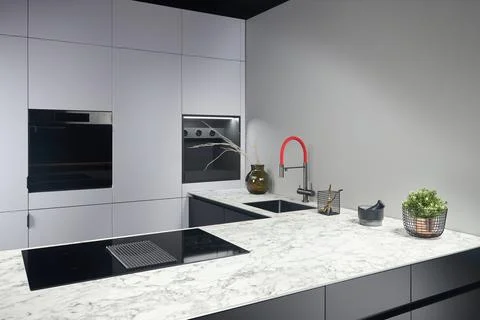 Upscale modern flat design loft kitchen with Induction cooker black glass hob Stock Photos