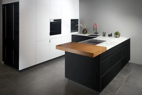 Upscale modern flat design loft kitchen with Induction cooker black glass hob Stock Photos