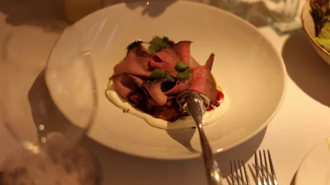 Upscale restaurant appetizer showcasing tender seasoned beef slices 库存影片 327013978