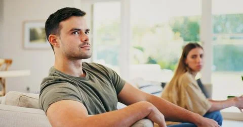 Upset, argument and man on sofa in home with conflict, breakup or cheating .. Stock Photos