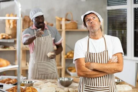 Upset baker reprimanded by boss in small bakery Stock Photos