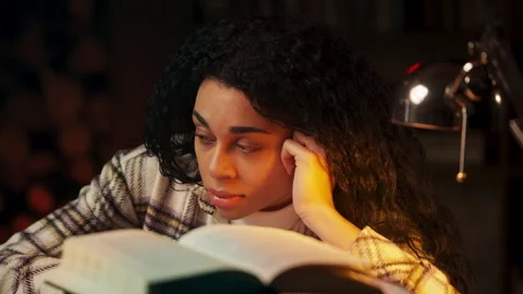 Upset Black student sitting behind books, tired from heavy academic workload Stock Footage 322902148