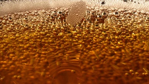 Upset bubbles in a gold drink Stock Footage 119369018