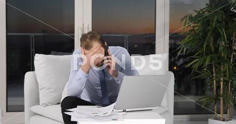 Upset Business Man Receive Bad News Talk on Phone Multitasking Activity on Sofa Stock Photos