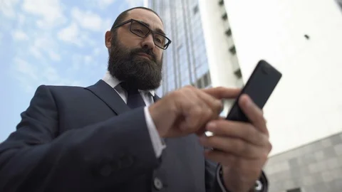 Upset businessman using mobile app on smartphone, displeased with technology 動画素材 117377995