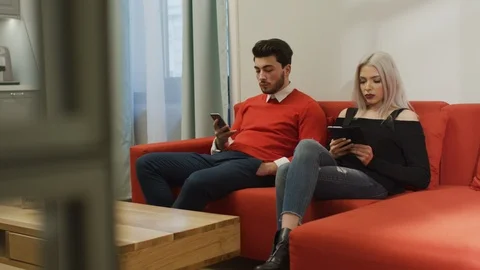 Upset couple sitting on a couch Stock Footage 99940833