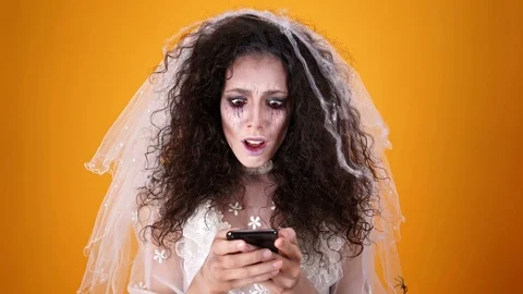 Upset crying dead bride with halloween makeup using phone Stock Footage 108857465