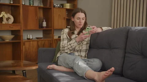 Upset Customer Browsing Online on Smartphone in Living Room Stock Footage 298289327