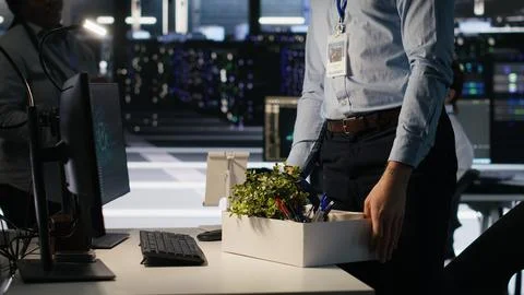 Upset data center worker packing desk after being replaced by AI Stock Photos