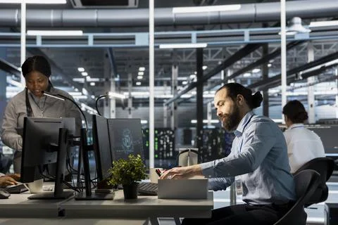 Upset engineer in data center replaced by AI packing desk items Stock Photos