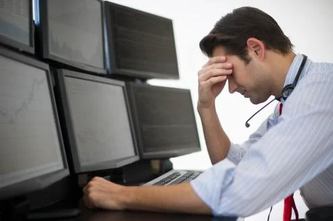 Upset financial worker analyzing data displayed on computer screen 스톡 사진