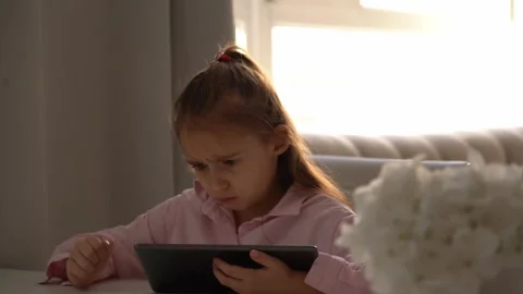 Upset Girl Using Tablet. Intensely focused on a gadget. school girl Stock Footage 277655853