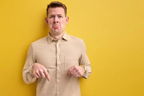Upset guy pointing index finger down, copy space Stock Photos