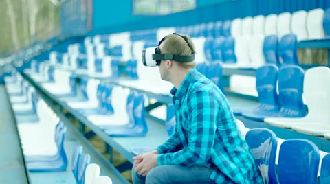 Upset guy in VR glasses sitting on the tribune Stock Footage 63843893