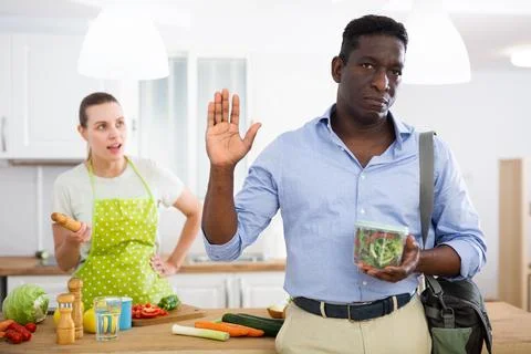 Upset husband going to work with lunch box Stock Photos