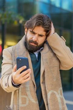 Upset Indian man using smartphone browsing, loses becoming shocked bad news on Stock Photos
