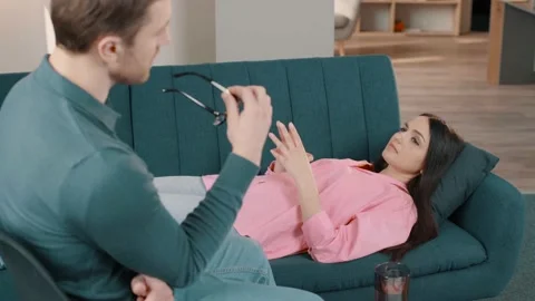 Upset lady lying on sofa and talking with psychologist at therapy session Stock Footage 236243387