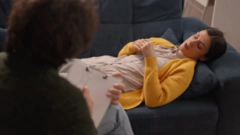 Upset lady lying on sofa and talking with psychologist at therapy session. Stock Footage 242010689