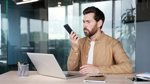 Upset male worker rejected while talking on mobile phone while sitting  Stock Footage 295039191