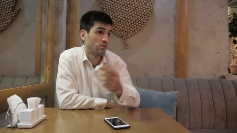 Upset man asks to take order by palms gesture in cafe Stock Footage 106328299