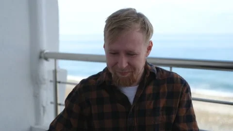 Upset man on the balcony overlooking the sea Stock Footage 201051401