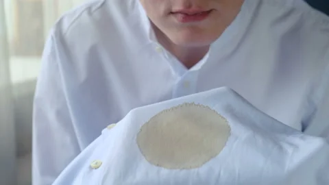 Upset man in connection with a coffee stain on his shirt, close-up 動画素材 130564503