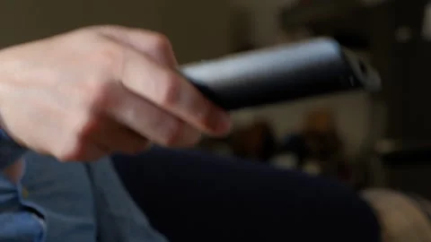 Upset man on couch pressing the buttons on the TV remote control Stock Footage 246492054