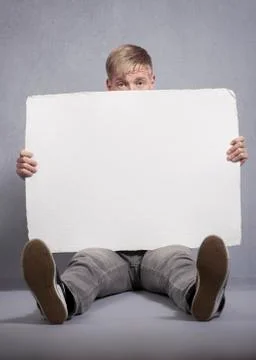 Upset man holding white empty panel. Stock Photos