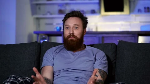 Upset man sitting on the sofa and watching football. Team is loosing. Stock Footage 122200633